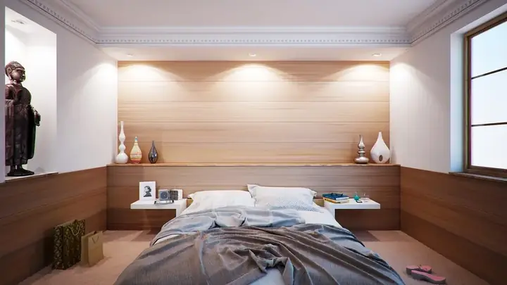 Bedroom with wood panelled wall and warm cove lighting